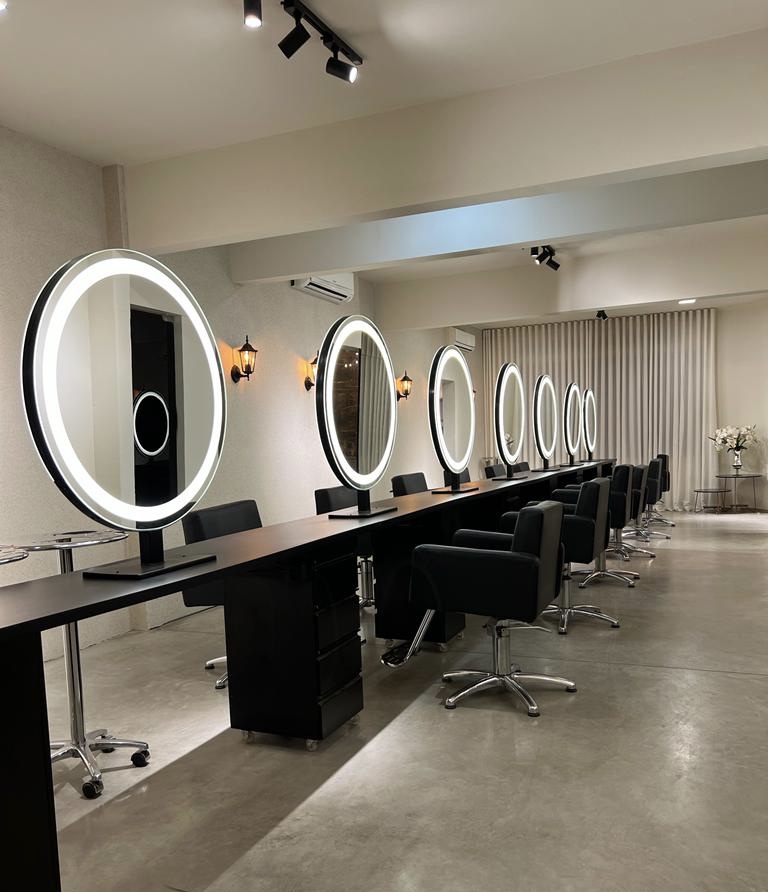 Interior do Krikor Concept Hair com espelhos circulares iluminados